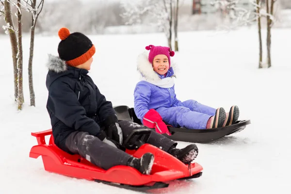 Щасливі маленькі діти ковзають на санчатах взимку — стокове фото