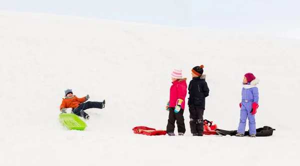 Gelukkig weinig kinderen met sleeën in de winter — Stockfoto