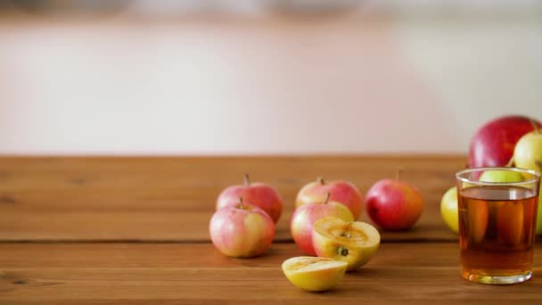 Glas und Flaschen Apfelsaft auf Holztisch — Stockvideo