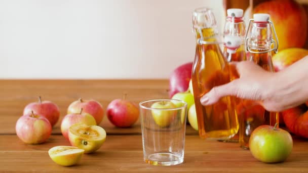 Ручной разлив яблочного сока из бутылки в стекло — стоковое видео