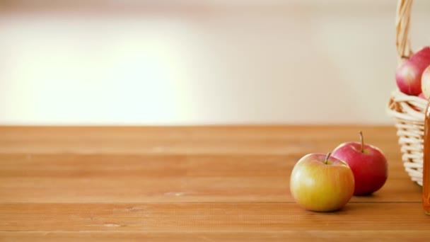 Manzanas en cesta y botellas de jugo en la mesa — Vídeo de stock