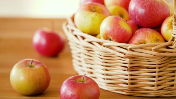 Ripe apples in wicker basket on wooden table — Stock Video