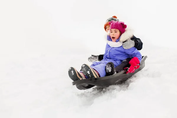 Enfants glissant sur traîneau sur la colline de neige en hiver — Photo