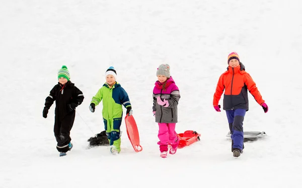 Gelukkig weinig kinderen met sleeën in de winter — Stockfoto