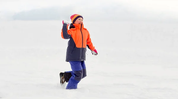 Menina feliz jogando e jogando bola de neve no inverno — Fotografia de Stock