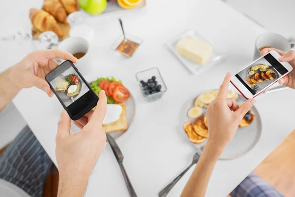 Kahvaltıda akıllı telefonlar ile çiftin yakın çekim — Stok fotoğraf
