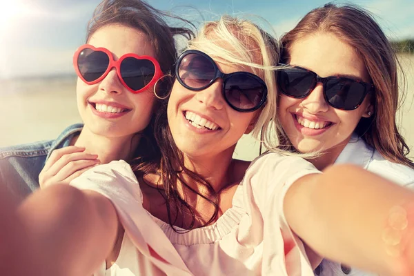 Grupo de mujeres sonrientes tomando selfie en la playa — Foto de Stock