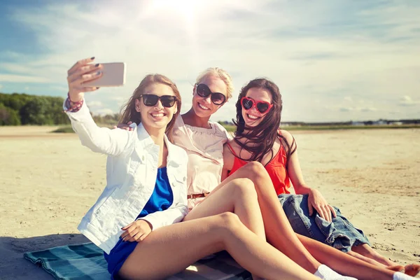 Grupa kobiet uśmiechający się biorąc selfie na plaży — Zdjęcie stockowe