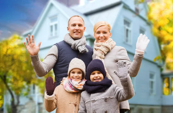 Gelukkige familie over levende huis in de herfst — Stockfoto