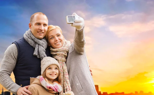 Família tomando selfie por câmera ao pôr do sol na cidade — Fotografia de Stock