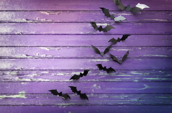 Black bats over ultra violet shabby boards — Stock Photo, Image