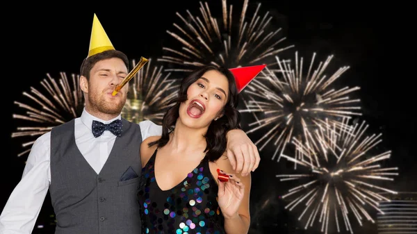 Happy couple with party blowers having fun — Stock Photo, Image