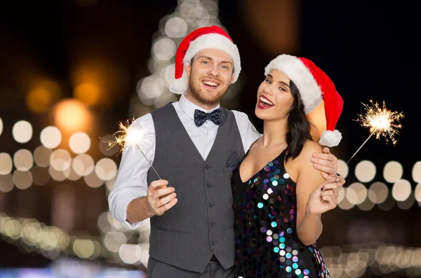 Casal feliz com sparklers na festa de Natal — Fotografia de Stock