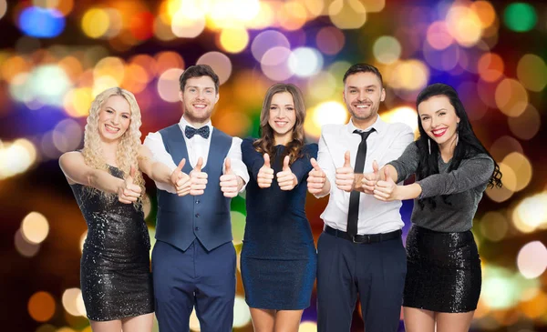 Amigos felizes em roupas de festa mostrando polegares para cima — Fotografia de Stock
