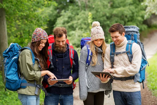 Vrienden of reizigers met rugzakken en tablet pc — Stockfoto