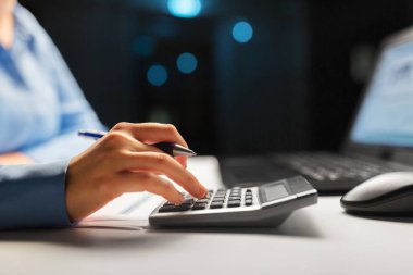 businesswoman with calculator at night office clipart