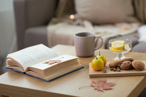 Bok, citron, te och kakor på bordet hemma — Stockfoto