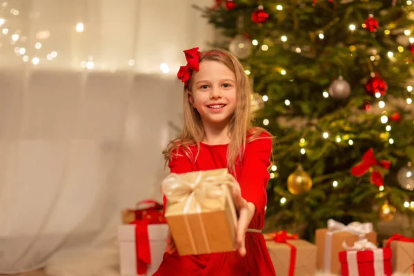 Усміхнена дівчина з різдвяним подарунком вдома — стокове фото
