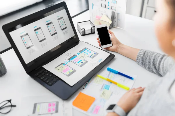 Návrhář webu s smartphone a notebook v kanceláři — Stock fotografie