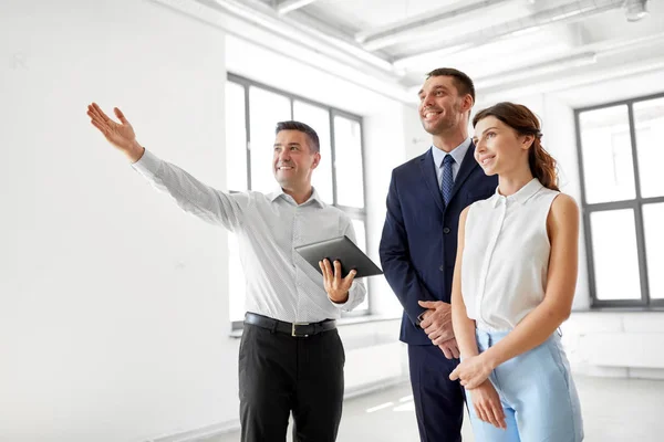 Fastighetsmäklare med TabletPC visar office till kunder — Stockfoto