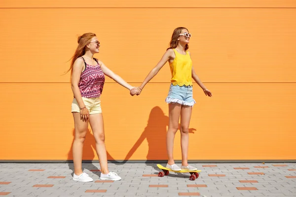 Chicas adolescentes montando monopatín en la calle de la ciudad — Foto de Stock