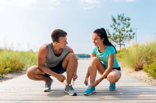 Par de corredores atando zapatillas cordones — Foto de Stock