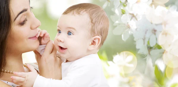 Mãe com bebê sobre fundo flor de cereja — Fotografia de Stock