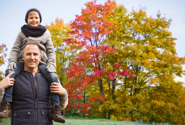 Šťastný otec přenesou syn podzimní park — Stock fotografie