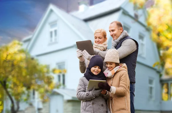 Familia con la tableta de la PC sobre la casa de estar en otoño — Foto de Stock