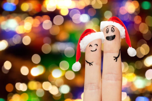 Finger par i santa hattar över lampor — Stockfoto