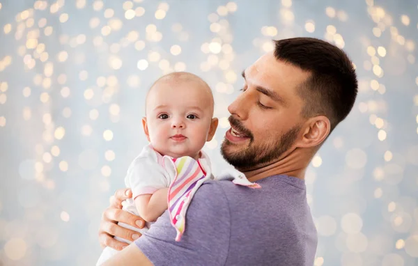 Padre con niña sobre luces festivas — Foto de Stock