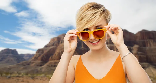 Portrait de jeune femme souriante en lunettes de soleil — Photo