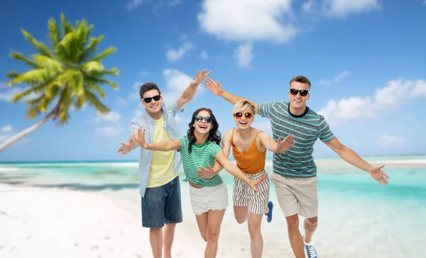 Friends in sunglasses having fun on tropical beach — Stock Photo, Image