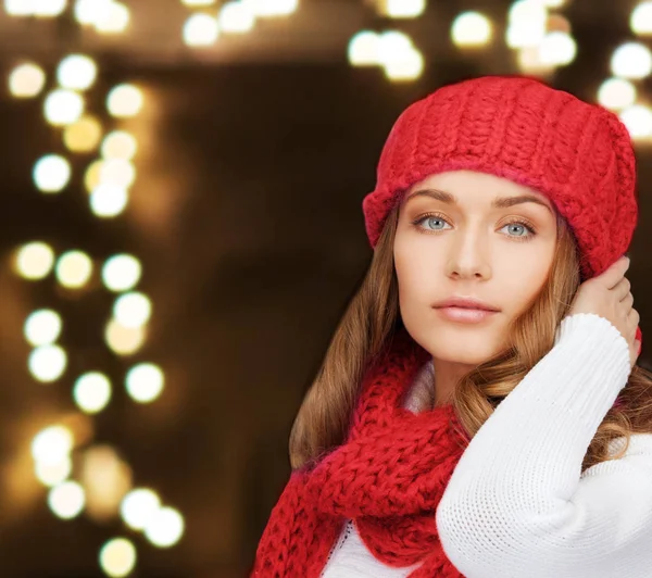 Žena v čepici a šálu přes světla pozadí — Stock fotografie