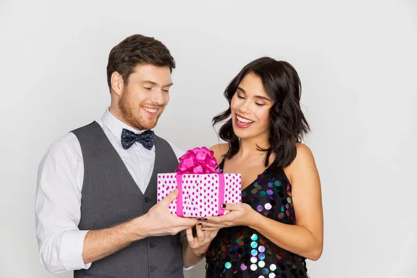 Casal feliz com caixa de presente na festa de aniversário — Fotografia de Stock