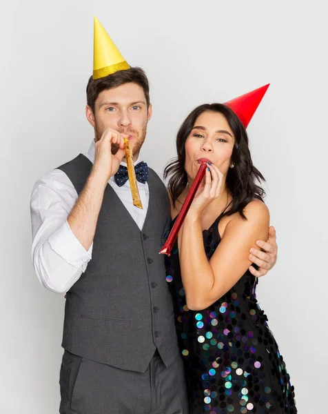 Casal feliz com sopradores de festa se divertindo — Fotografia de Stock