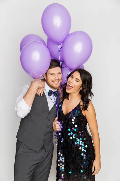 Feliz pareja con ultra violeta globos en la fiesta — Foto de Stock