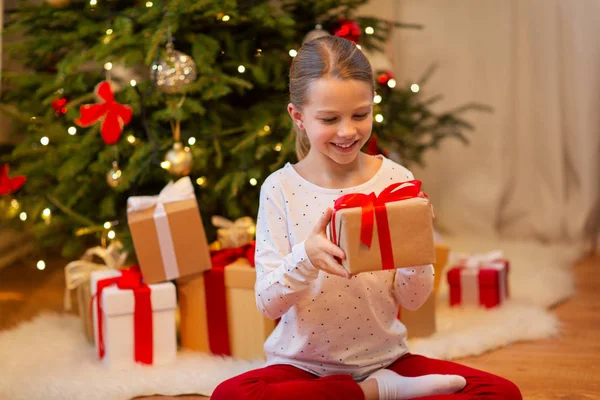 Leende flicka med julklapp hemma — Stockfoto