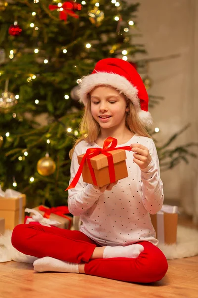 Fille souriante dans le chapeau de Père Noël avec cadeau de Noël — Photo