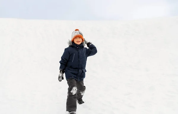 Glücklicher Junge, der im Winter Schneeball spielt und wirft — Stockfoto