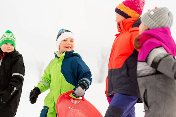 Счастливые маленькие дети с санками зимой — стоковое фото