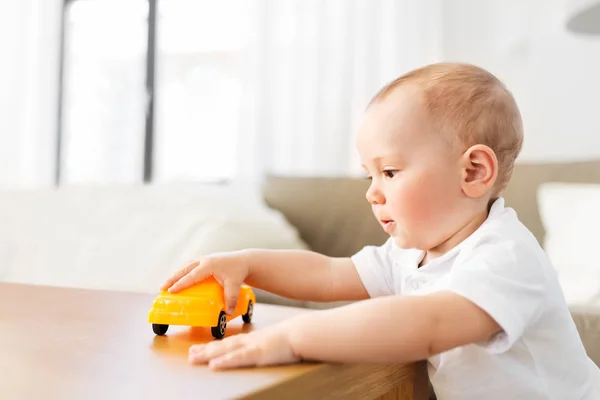 自宅のおもちゃの車で遊ぶ男の子の赤ちゃん — ストック写真