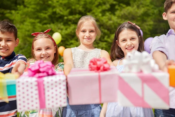 Glada barn med gåvor på födelsedagsfest i sommar — Stockfoto