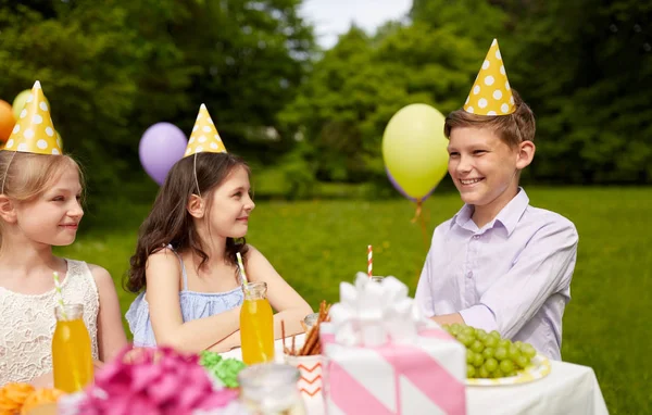 Glada barn på födelsedagsfest på sommarträdgård — Stockfoto