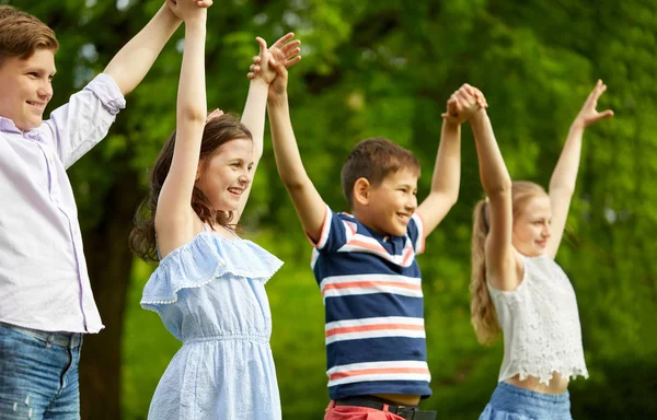 保持している幸せな子供たちは、夏の公園で手を上げた — ストック写真