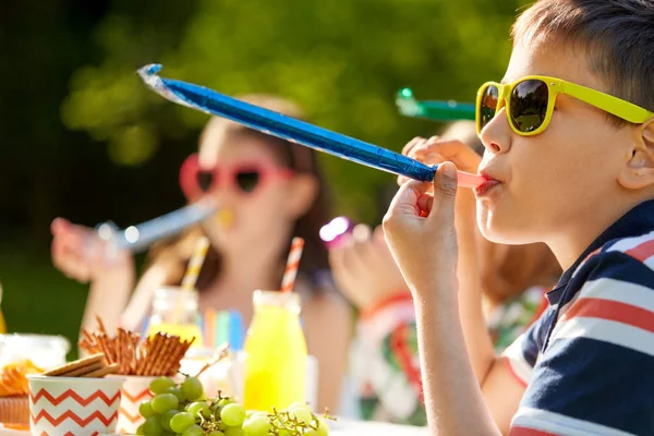 Enfants soufflant cornes de fête à l'anniversaire en été — Photo