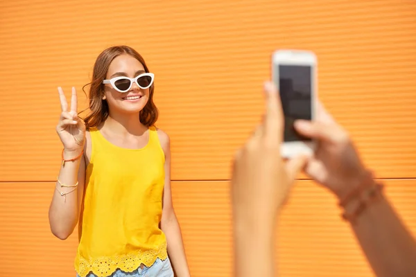 Teenage girl photographing friend by smartphone — Stock Photo, Image