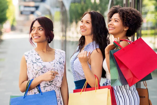 Mulheres felizes com sacos de compras na cidade — Fotografia de Stock