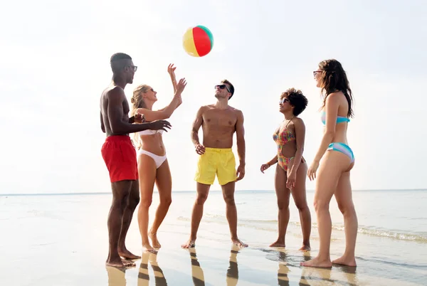 Vrienden met strandbal spelen in de zomer — Stockfoto