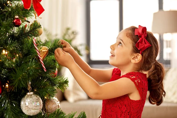 Little girl decorating christmas tree at home — Stock Photo, Image